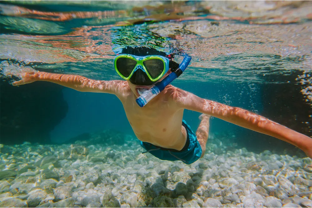 Jongen snorkelt onder water